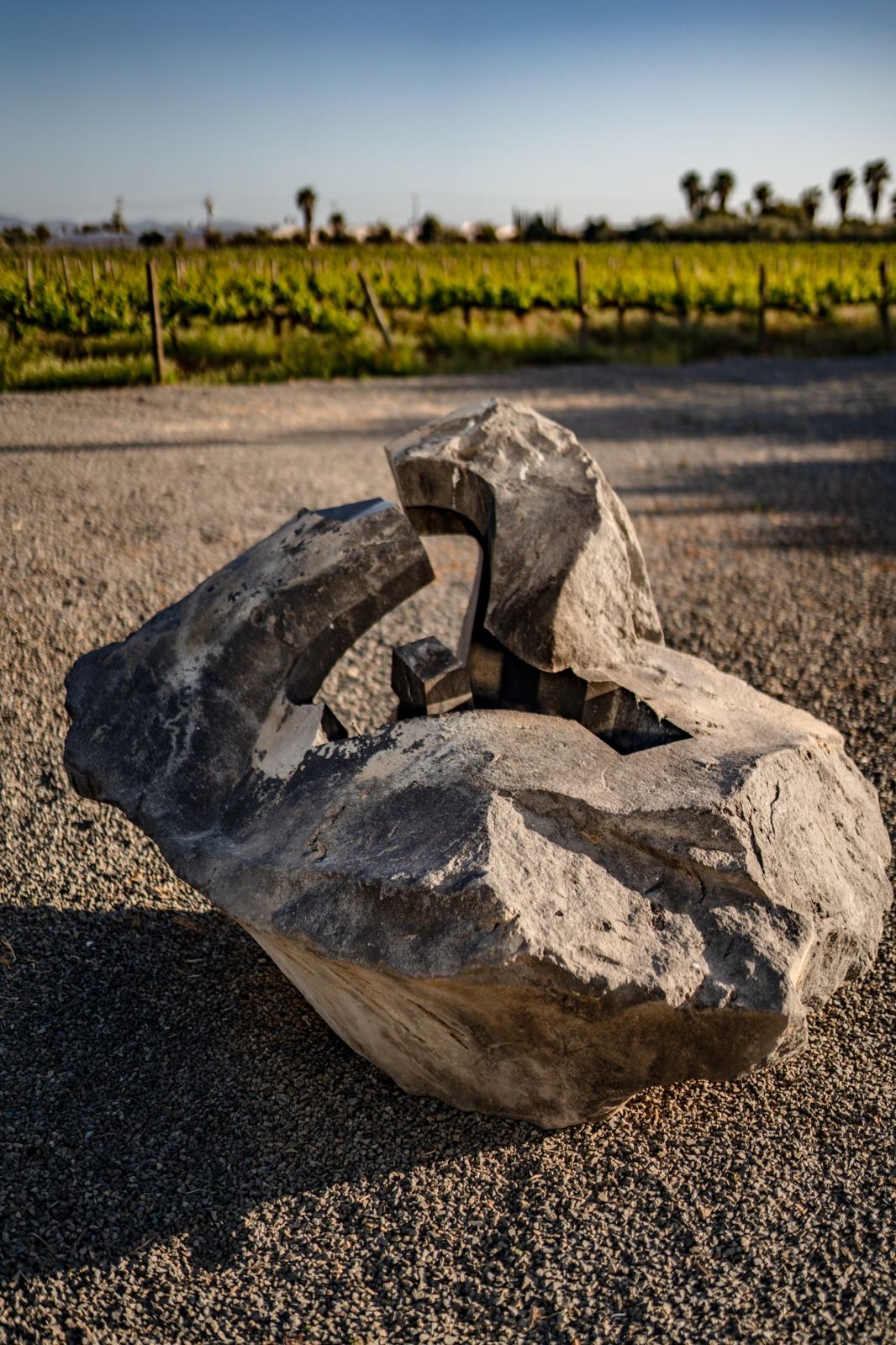 Escultura de piedra volcánica de Jorge Yázpik frente al viñedo