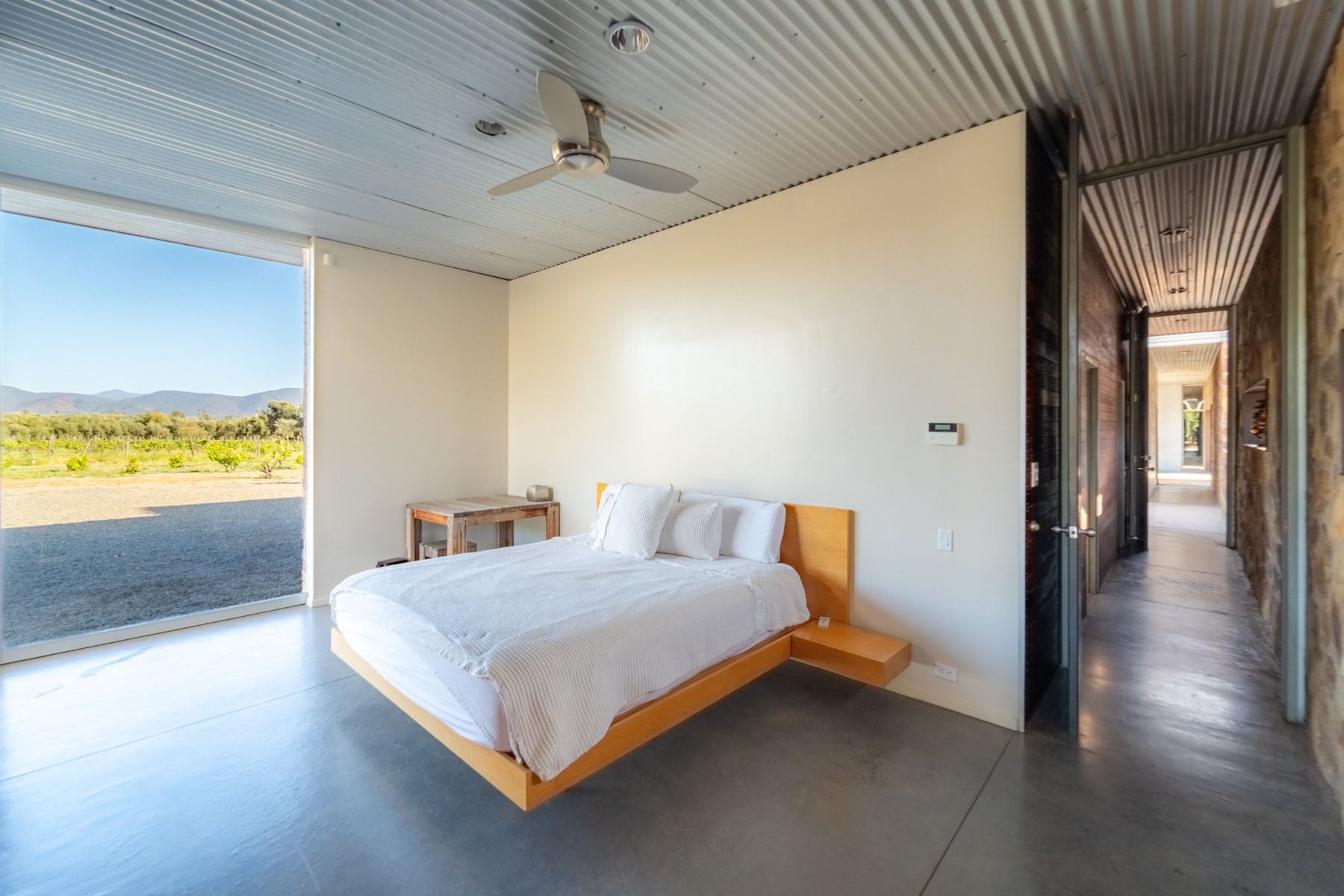 Suite con cama flotante y ventanal hacia viñas y montañas